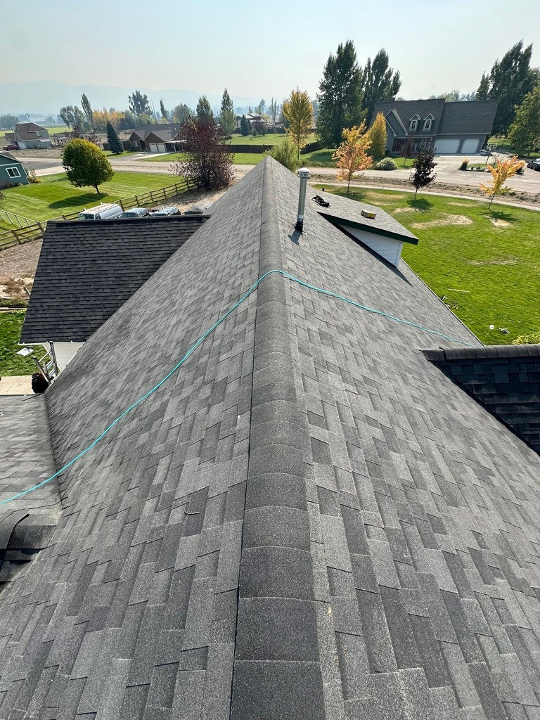 Completed asphalt shingle roof with centered ridge detail